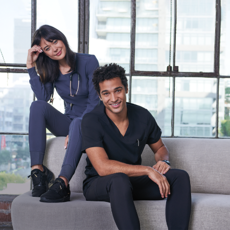 Dentist and Hygienist in their dental scrubs relaxing on the sofa with the glass background model